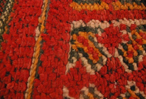 Roter handgeknüpfter Teppich, Detail des textilen Objekts